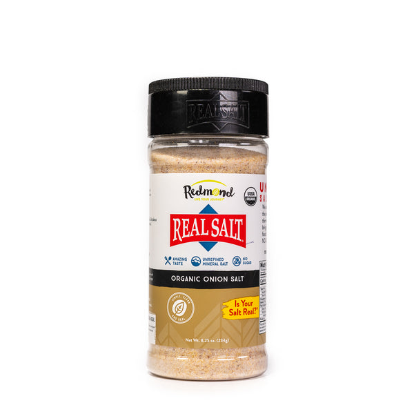 A clear shaker displays Redmond Real Salt Organic Onion Salt against a white background.