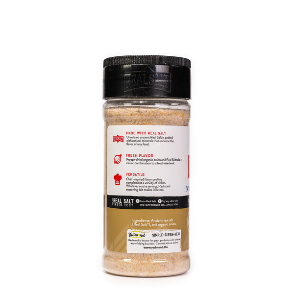 Clear shaker of Redmond Real Salt's onion salt seasoning against a white background.