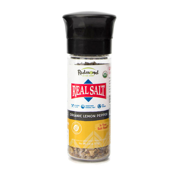 Redmond Real Salt Organic Lemon Pepper grinder features a black lid and displays the brand and product name with a transparent section revealing the seasoning. 
