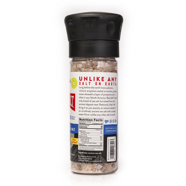 Clear grinder filled with coarse Redmond Real Salt, an unrefined, ancient sea salt.